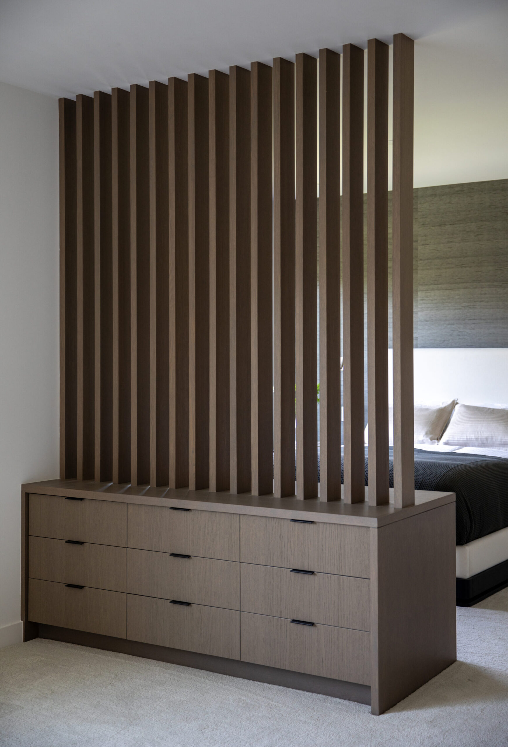 Custom wood slat room divider with built-in drawers