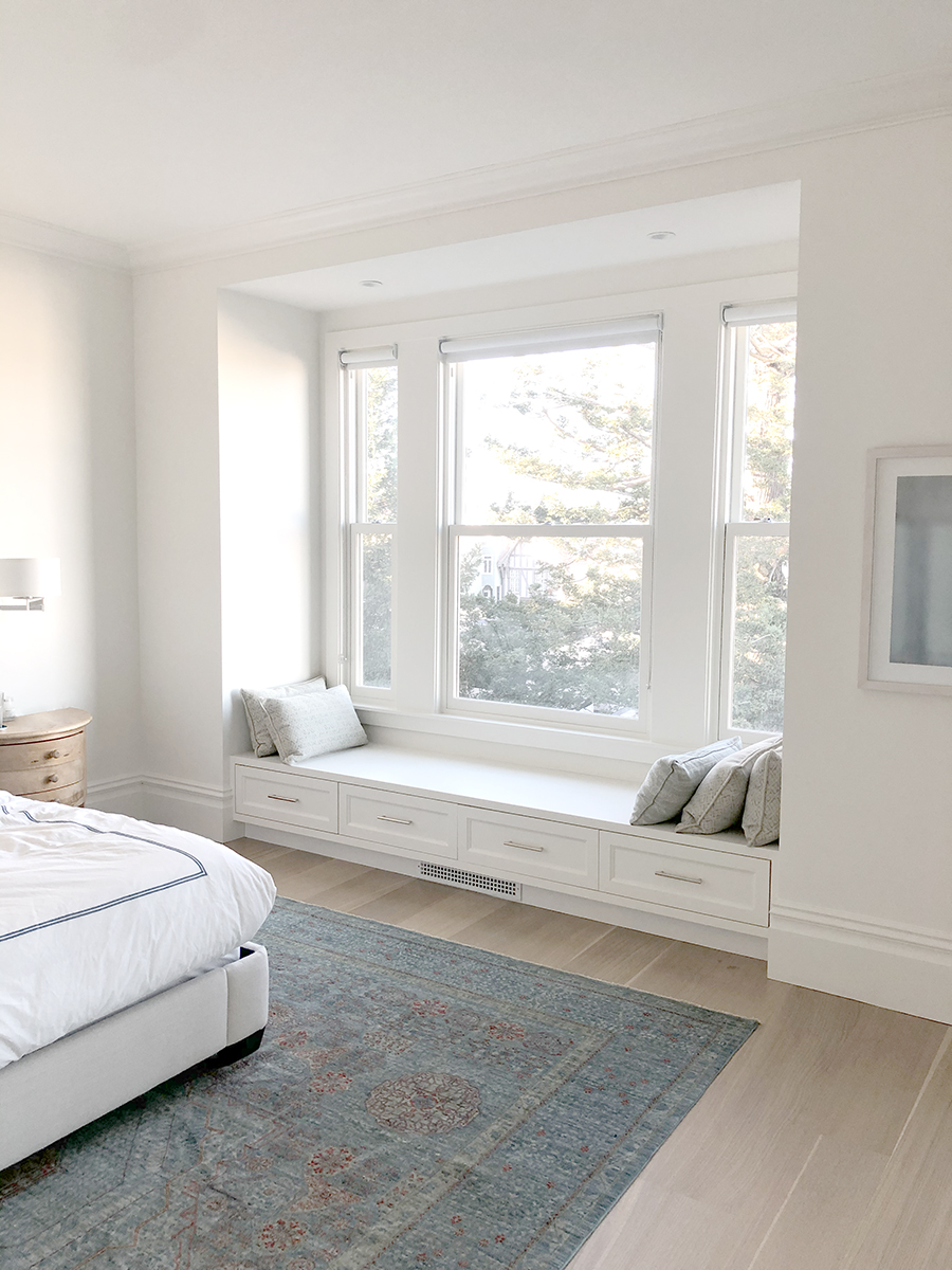 Built-in window seat with drawers in a bright bedroom