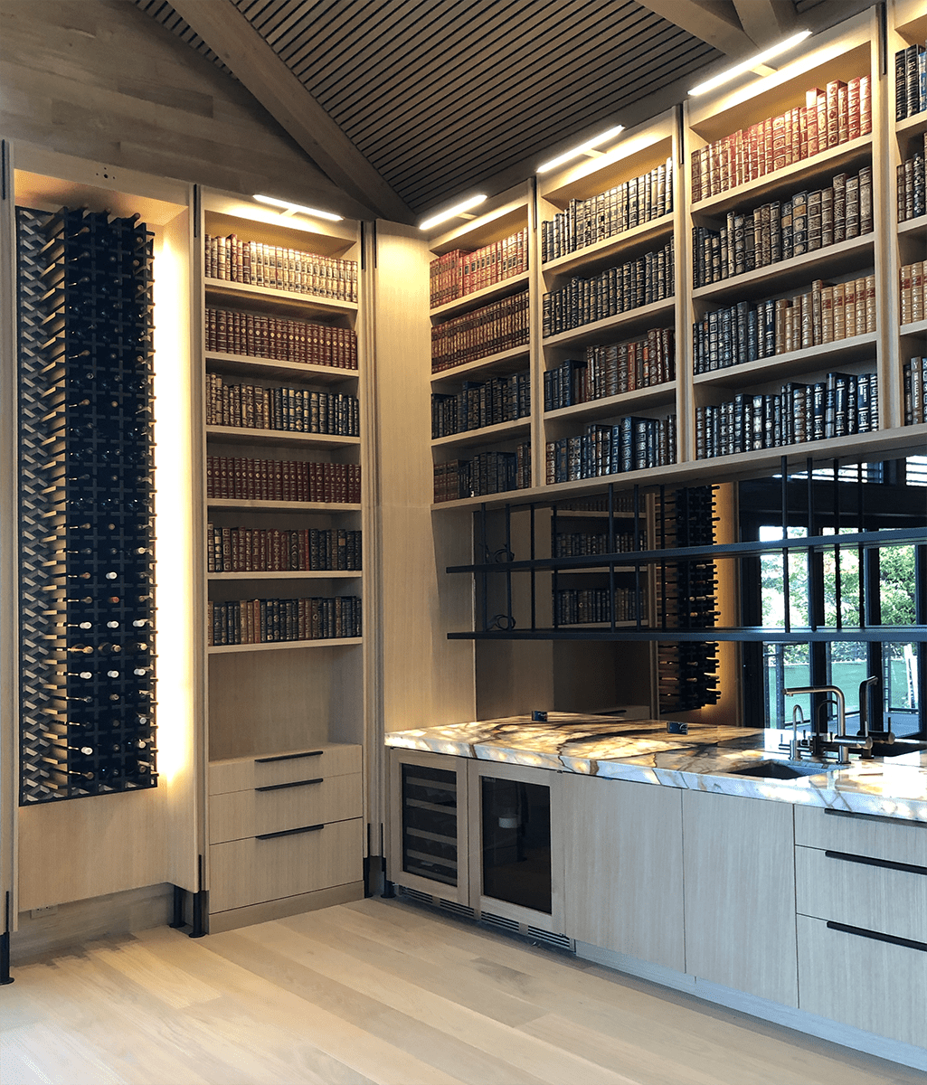 Custom library shelving and wine storage with light wood cabinetry